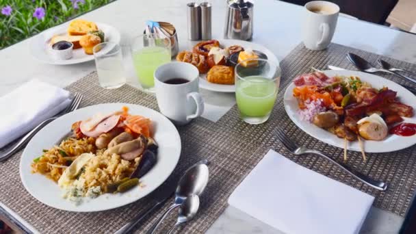 Colazione in Hotel di Lusso. Piatti pieni di cibo, succhi di frutta e caffè in tavola — Video Stock