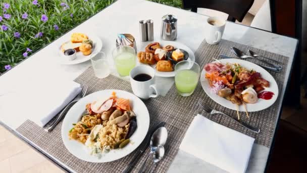 Desayuno en Hotel de Lujo. Platos llenos de alimentos, jugos y café en la mesa — Vídeo de stock