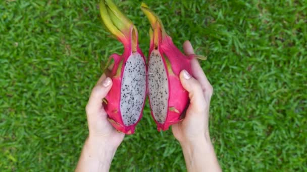 Großaufnahme von Frauenhänden, die zwei Hälften frischer weißer Drachenfrucht Pitaya öffnen — Stockvideo