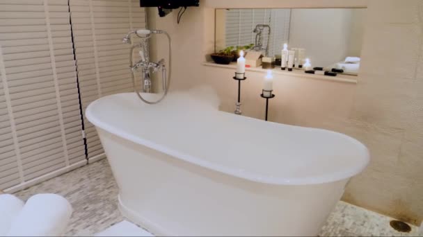 Baignoire vide avec bulles et mousse dans la salle de bain de luxe avec bougies — Video