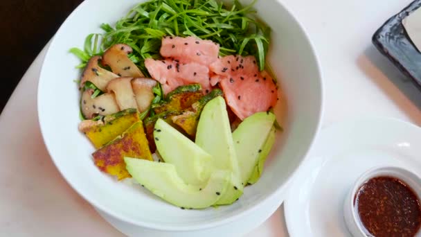 Salmon Poke Bowl with Avocado, Zucchini, Top View. Salad with Raw Fish — Stock Video