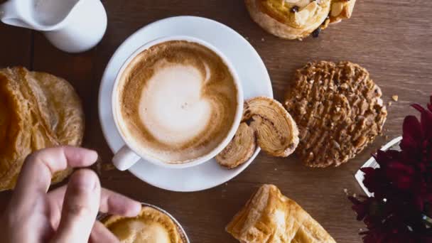 Café da manhã com croissants, torta, biscoito e xícara de café na mesa de madeira no café — Vídeo de Stock