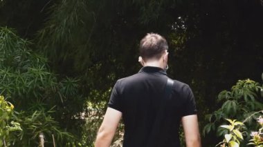 Yüz maskeli ve Yeşil Ormanda Yürüyen Adam 'ın Arka Görünümü