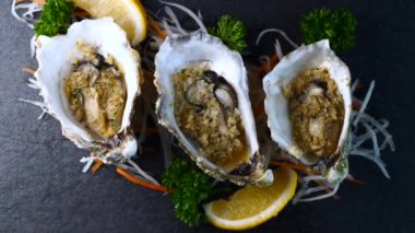 Kabuklu istiridye, sarımsaklı ve limonlu siyah desenli arkaplan.