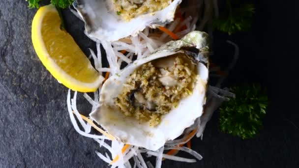 Fresh Raw Oysters in Shells with Lemon on on Black Textured Slate Stone, Top View — Stok Video