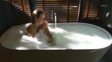 Seksi Şehvetli Kadın Rahatlıyor, Gözlerini Kapıyor ve Küvette Köpüklü Banyo Yapıyor