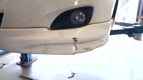 Primer plano de los arañazos en el parachoques en la máquina elevadora de automóviles en el centro de servicio — Vídeos de Stock