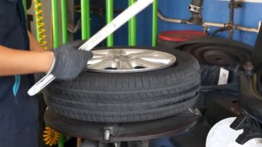 Otomatik Tamir Servisinde Lastiği Kaldırmak için Bağlama Aracı Makinesi Kullanılıyor