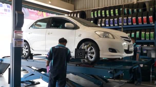 Mechanic Doing Wheel Balancing van Lifting Car met apparatuur op het tankstation — Stockvideo