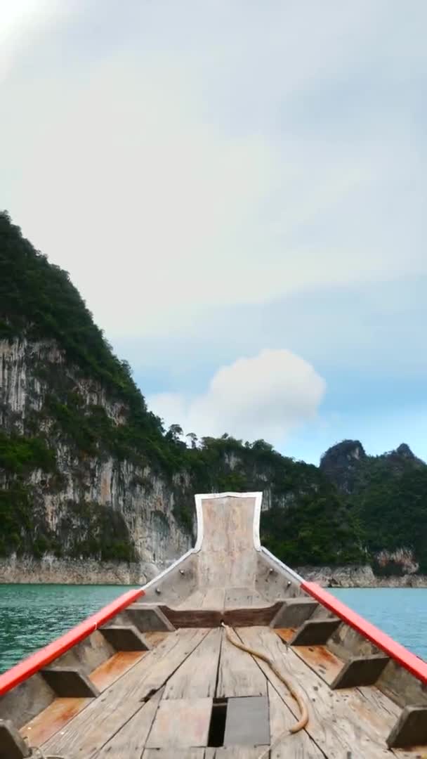 Vertical Video of Travel on Blue Lake on Wood Longtail Boat Near Limestone Cliff — Stock Video