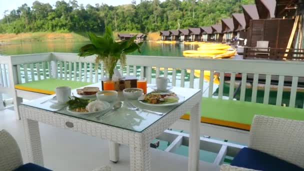 Desayuno en la naturaleza en el restaurante al aire libre en el lago con casa de madera en el agua — Vídeos de Stock