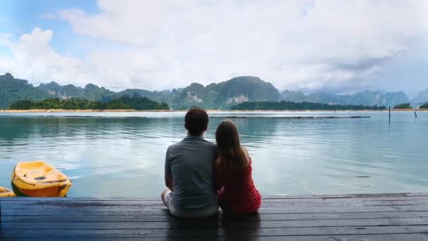 Pareja romántica feliz sentados juntos en el puente de madera en Green Mountains Lake — Vídeos de Stock