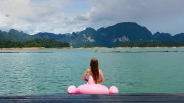 Mutlu Kadın Mavi Göl 'deki Pembe Şişirilebilir Flamingo' da Eğleniyor ve Aylaklık Ediyor