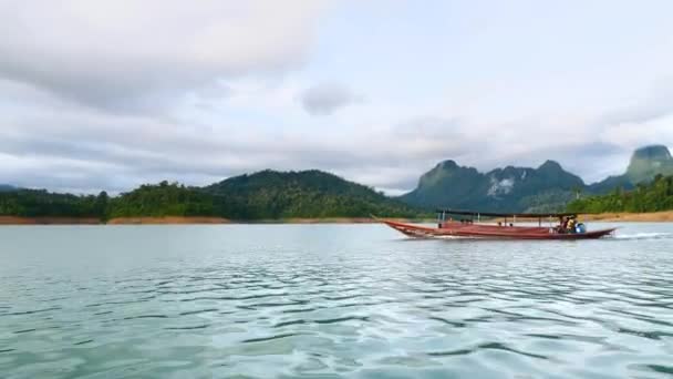 Traditionele houten boot zeilen op Blue Lake met Green Rain Forest Mountains — Stockvideo