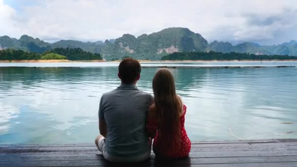 Pareja romántica feliz sentados juntos en el puente de madera en Green Mountains Lake — Vídeos de Stock