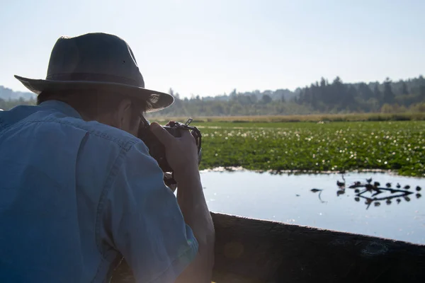 帽子とサングラスで鳥の写真を撮っているアジア人男性の肩越しのショット バンクーバーBcカナダ — ストック写真