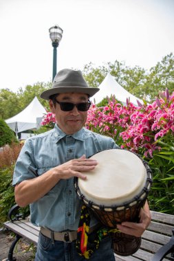 Djembe çalan Asyalı bir adam. Vancouver BC Kanada