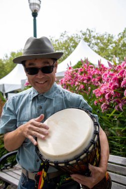 Bir djembe 'ye çarpan Asyalı bir adamın resmi. Vancouver BC Kanada