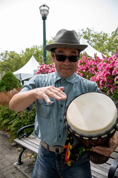 Djembe çalan Asyalı bir adam. Vancouver BC Kanada