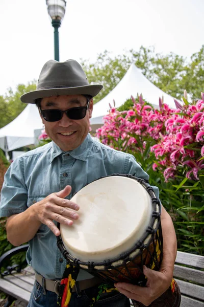 Bir djembe 'ye çarpan Asyalı bir adamın resmi. Vancouver BC Kanada