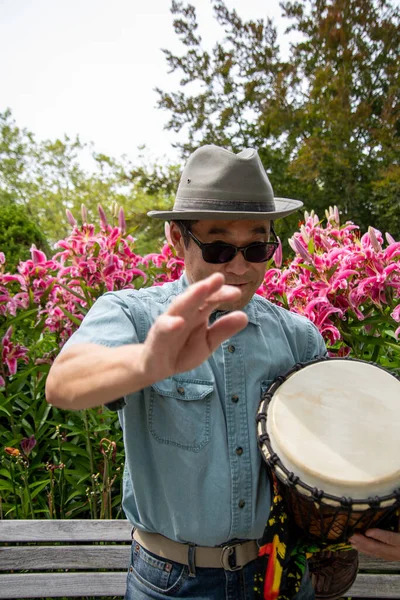 Bir djembe 'ye çarpan Asyalı bir adamın resmi. Vancouver BC Kanada