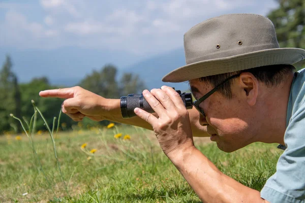 Una Visione Laterale Uomo Sdraiato Campo Usando Binocolo Indicando Qualcosa — Foto Stock