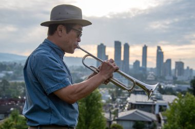 Güneş ışığına karşı trompet çalan bir adamın resmi. Vancouver BC Kanada