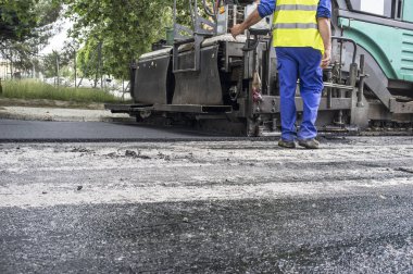 Şehrin asfalt döşeme çalışıyorum. Aplikatör makine ya da işçi ile finişer parke