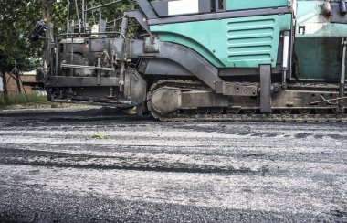 Şehrin asfalt döşeme çalışıyorum. Aplikatör makine veya iş yerinde finişer parke