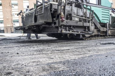 Şehrin asfalt döşeme çalışıyorum. Aplikatör makine veya iş yerinde finişer parke