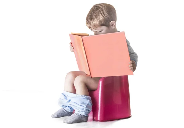 Bambino seduto sulla pentola da camera a leggere un libro — Foto Stock