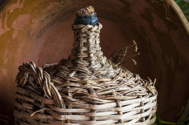 Old lined wicker carafe former used for home wine transport. Closeup clipart