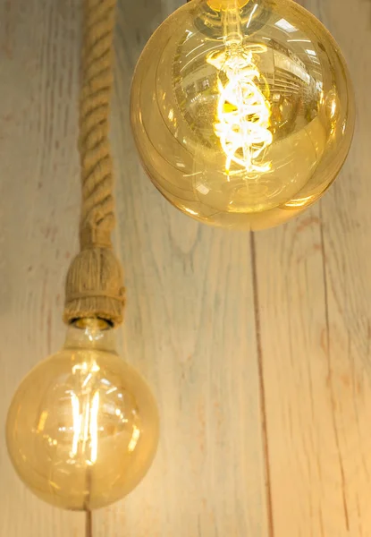 Rope light bulbs over weathered wooden background. Low angle view