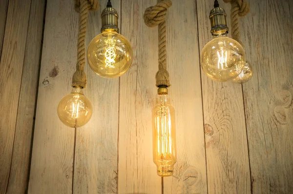 Rope light bulbs over weathered wooden background. Low angle view