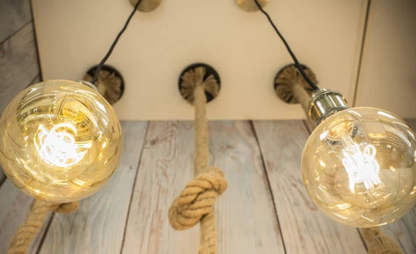 Rope light bulbs over weathered wooden background. Low angle view