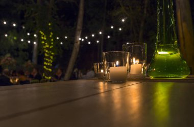 Düğün konuklar bahçe mum ışıkları ile yemek. Işıklı bokeh arka plan