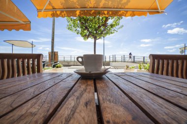 Portekizce espresso kahve Kupası ya da bica ahşap masa üzerinde. Cabanas de Tavira, Algarve, Portekiz terasında rahatlatıcı