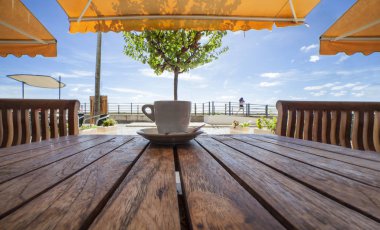 Cabanas de Tavira, Portekiz - 14th Ekim 2018: Portekizce espresso kahve fincan ya da bica ahşap masa üzerinde. Cabanas de Tavira, Algarve, Portekiz terasında rahatlatıcı