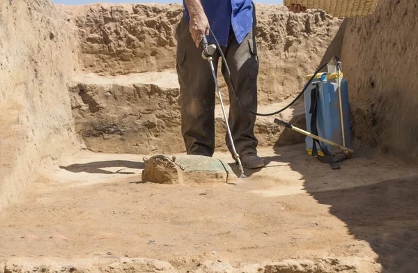 专业人员在考古遗址喷洒了一块半埋青铜的青铜 西班牙埃斯特雷马杜拉 — 图库照片