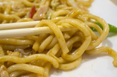 Udon yemek çubukları arasında. Japon mutfağında kullanılan kalın makarna türü