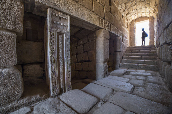 Visitor at North entry of Arabic water cistern at Alcazaba citadel. Merida, Extremadura, Spain. Interior view