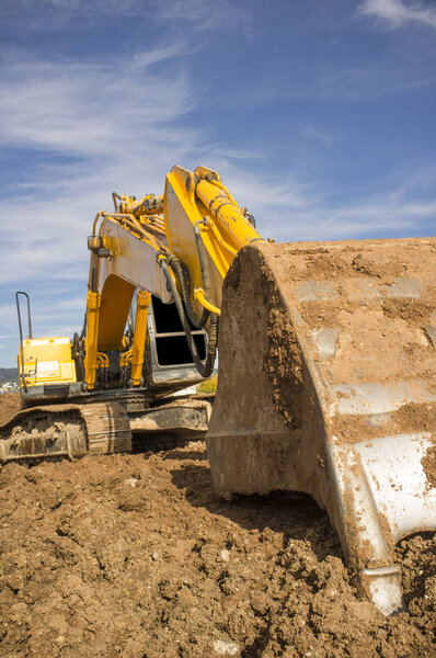 Earthmoving excavator preparing the construction site soil. Scoop detail