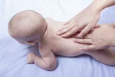 Sırt masajı 3 aylık erkek bebek için. Kadın masaj terapist eller