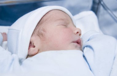 Yukarı yönde pozisyon uyuyan yeni doğmuş bebek. Birkaç saat-eski bebek hastane yatağı