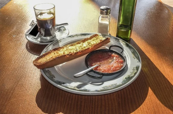 Typical spanish breakfast, coffee and toast with olive oil and grinded natural tomato, Sunny table early in the morning