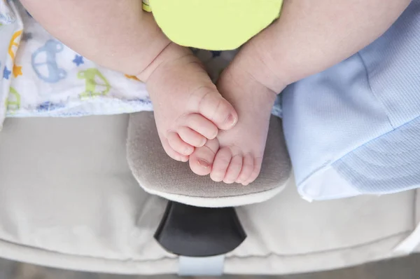 刚出生的婴儿胖乎乎的脚在 尺寸的婴儿车上 在婴儿车上 间接开枪 — 图库照片