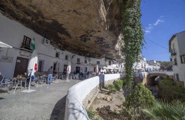 Street with dwellings built into rock overhangs. Setenil de las  clipart