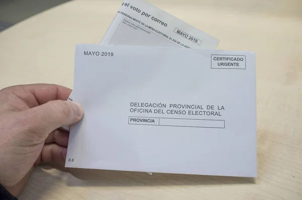 Зріла людина тримає форму запиту і конверт для заочного голосування або — стокове фото