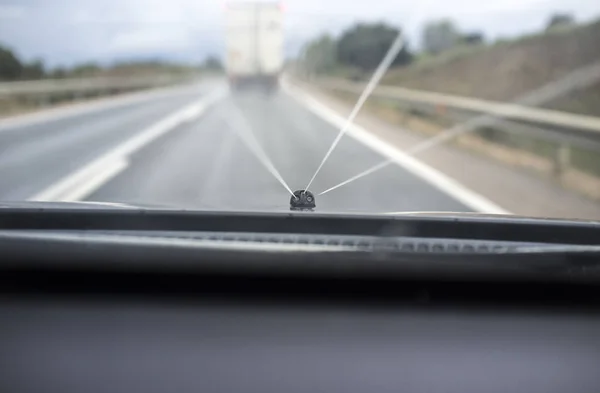 Laveuse de verre en action alors qu'il conduit derrière un camion lent — Photo