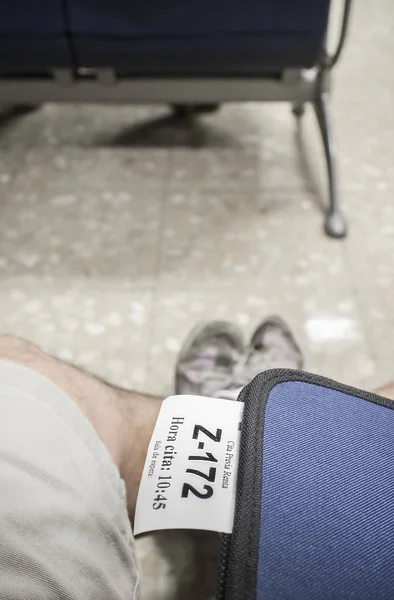 Folder with Tax Agency appointment ticket over male legs at wait — Stock Photo, Image